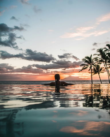 Infinity pool at sunset with palm trees
